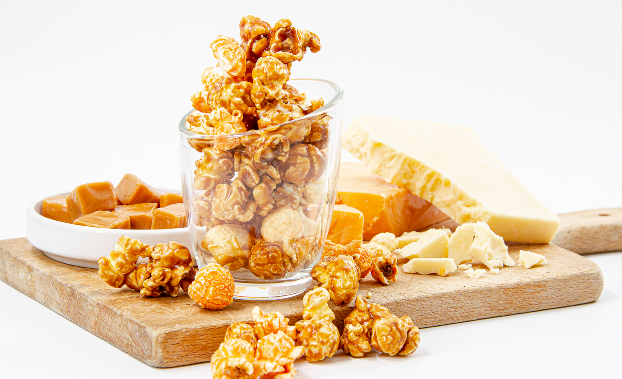 C3 - Cheese, Cheese & Caramel Popcorn displayed on cutting board with caramels and cheese cubes