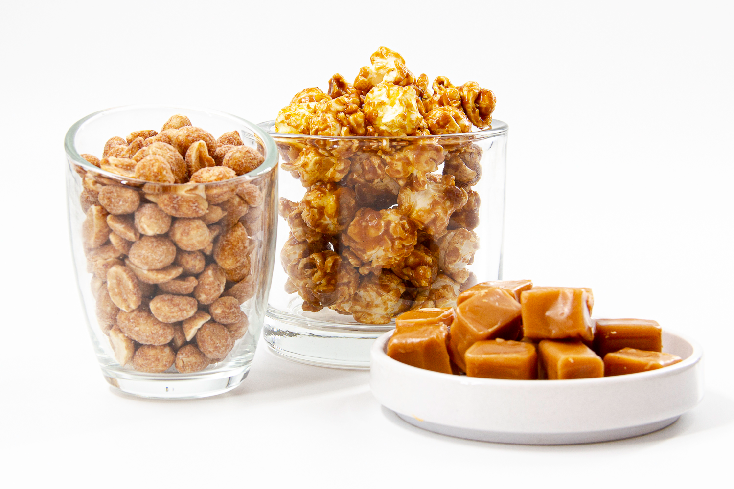 caramel popcorn and peanuts displayed in clear cups