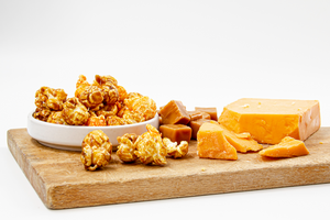 Chicago mix popcorn. Sweet, crunchy caramel and salty, savory cheddar cheese flavors. Popcorn displayed with chucks of cheese and caramel candies.