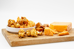 Load image into Gallery viewer, Caramel and Cheese popcorn displayed on cutting board
