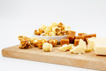 Load image into Gallery viewer, Caramel and White Cheddar Popcorn displayed on wood cutting board
