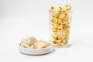Garlic Parmesan Popcorn displayed with garlic clove in clear cup